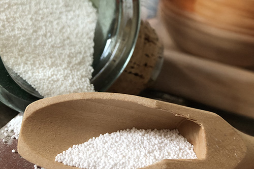 cuillère en bois avec une dose de percarbonate de soude